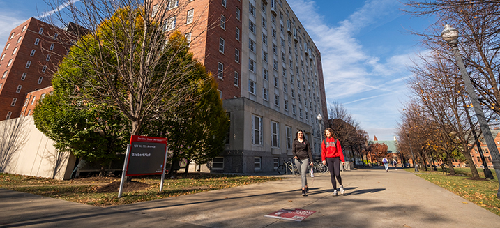 Two students walking outside residence hall