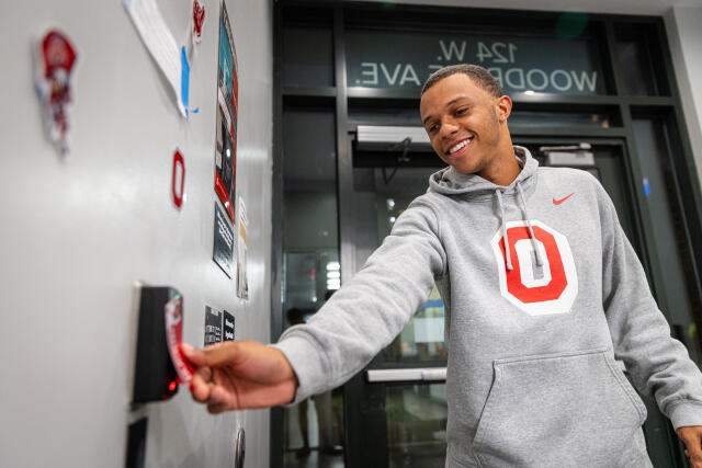 Person tapping a BuckID to enter a residence hall